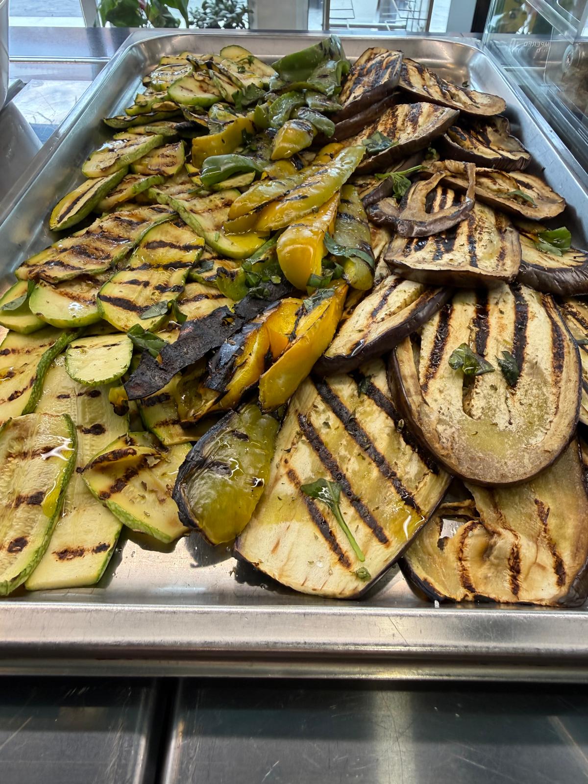 Teglia d'acciaio al banco di Lo Spizzico con zucchine, melanzane e peperoni gialli e verdi grigliati, olio e foglie di menta