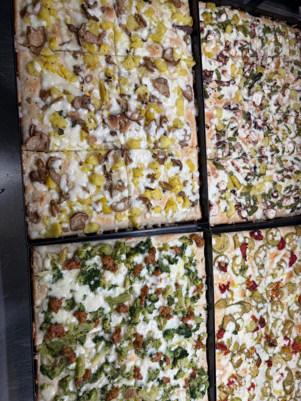 Teglie di pizze farcite gourmet con verdure e salumi